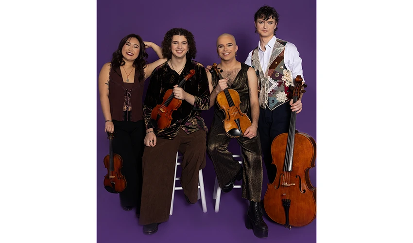 photo of four young musicians seated and standing and holding their string instruments against a purple backdrop